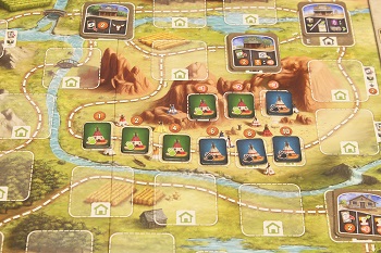 closeup of the game board with cards and tokens laid out upon it