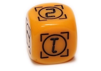 an orange rounded die, showing three sides with the numbers '1', '1', and '2'