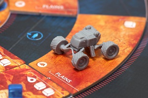 closeup of the game board with a grey, plastic miniature vehicle upon it