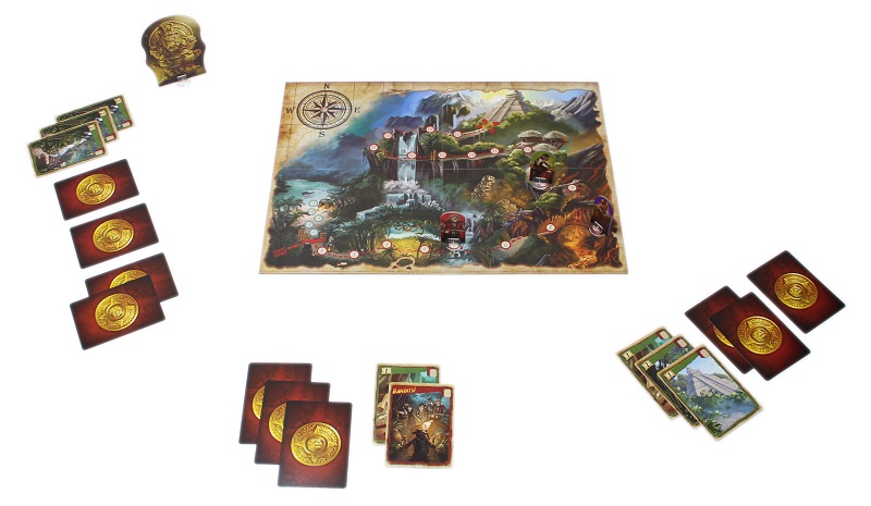 several game components spread out on display, including game board, cards (both face-down and face-up), as wel as one board game piece depicting a statue