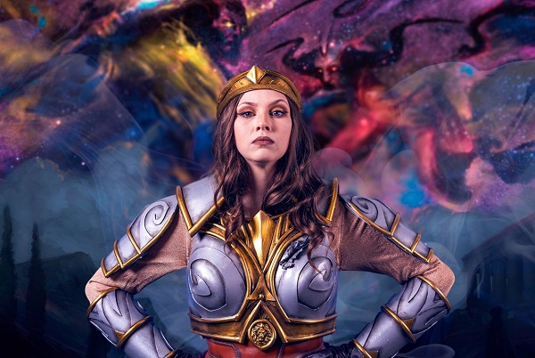 An image of a woman cosplaying at the Magic character Elspeth Tirel. She wears a costume of crafted, ornate armor.