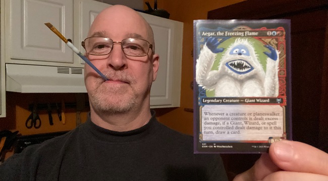 The author of this article holding a paintbrush in his mouth and a copy of Aegar altered to look like the Abominable Snowman